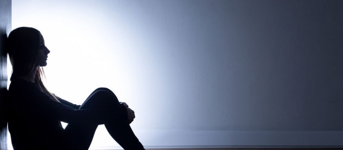 51275128 - teenager with depression sitting alone in dark room